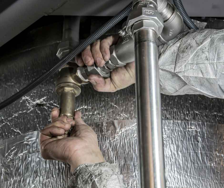 A plumber working on pipes